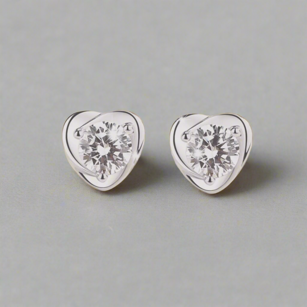 This heart-shaped sterling silver stud earring features a dazzling crystal at its center, catching and reflecting light beautifully. The sleek silver setting highlights the crystal's sparkle, creating an elegant and timeless accessory. Perfect for adding