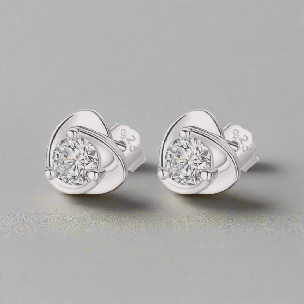 This heart-shaped sterling silver stud earring features a dazzling crystal at its center, catching and reflecting light beautifully. The sleek silver setting highlights the crystal's sparkle, creating an elegant and timeless accessory. Perfect for adding