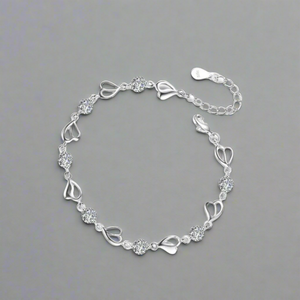 Crafted with 925 solid sterling silver hearts, this retro charm bracelet is a versatile accessory for women, perfect for any occasion. Adorned with sparkling crystals, this original piece adds a touch of elegance to any outfit. Add this to your jewelry collection for a piece to wear anywhere anytime.