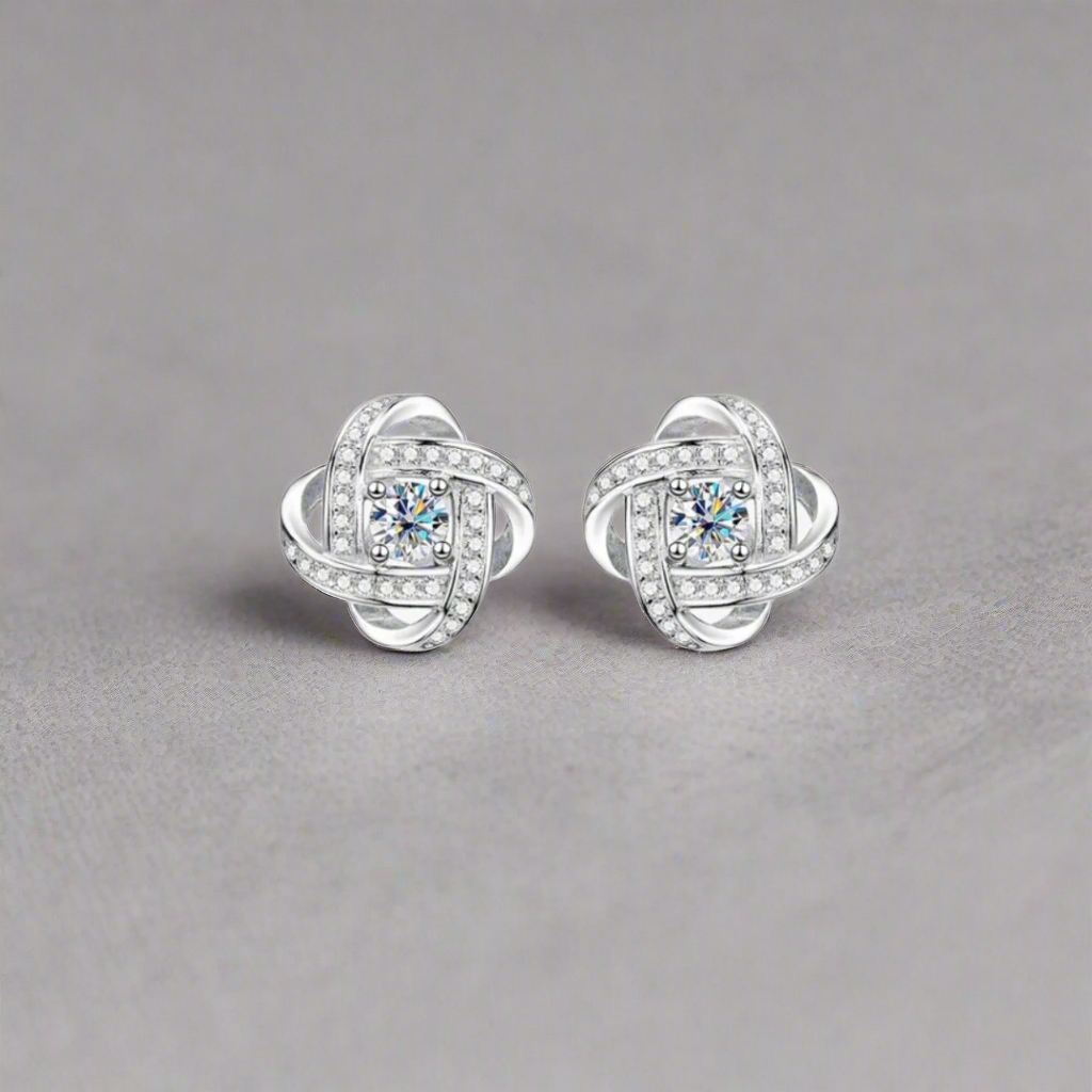 Crystal Knot Silver Stud-These studs are crafted from 925 Sterling Silver, known for its durability and bright, polished finish. The design features a sophisticated knot shape, elegantly intertwined, and adorned with sparkling zircon stones. The central z